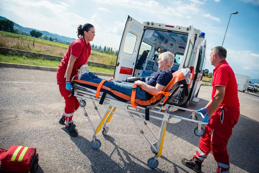 An image depicting a driver urgently calling for medical assistance on behalf of the injured party in a crash, highlighting the driver's responsibility.